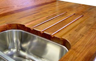 Mesquite edge grain countertop with an integrated sloping drainboard for an undermount sink.