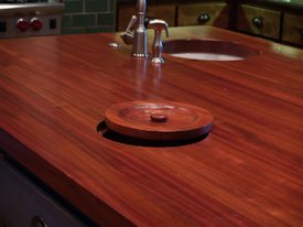 Jatoba edge grain custom wood island countertop with hand carved trash cover.
